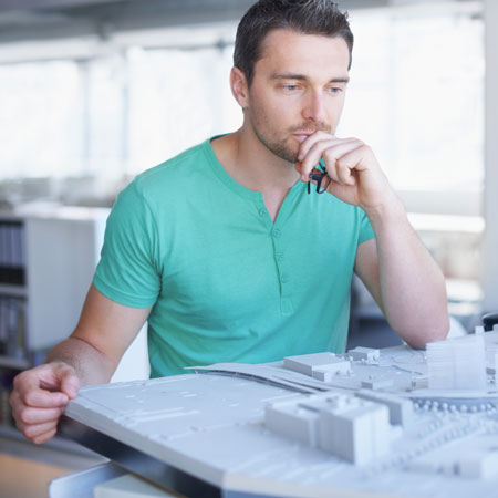 Human stares intently at model buildings